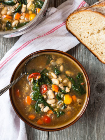 italian white bean soup in a serving bowl with bread