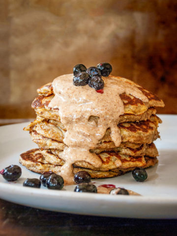stack of banana pancakes with almond butter and blueberries
