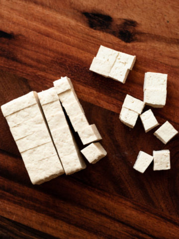 tofu cut into cubes on cutting board