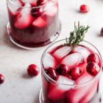 cranberry spritz in two glasses with rosemary sprigs