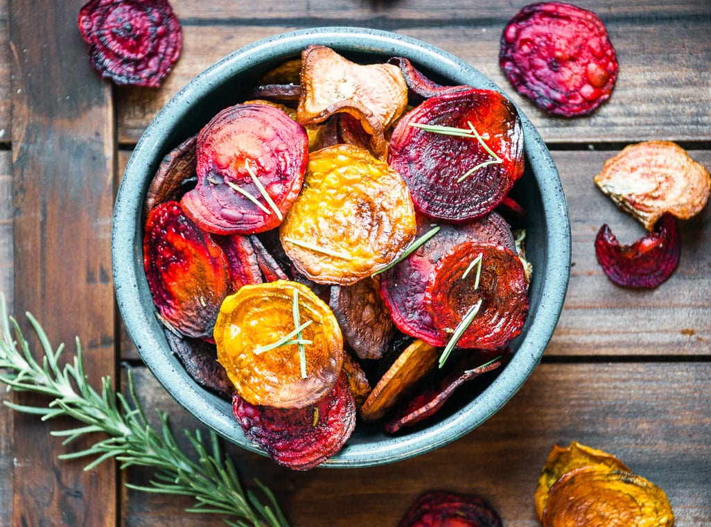 beet chips in a blue bowl on wood background