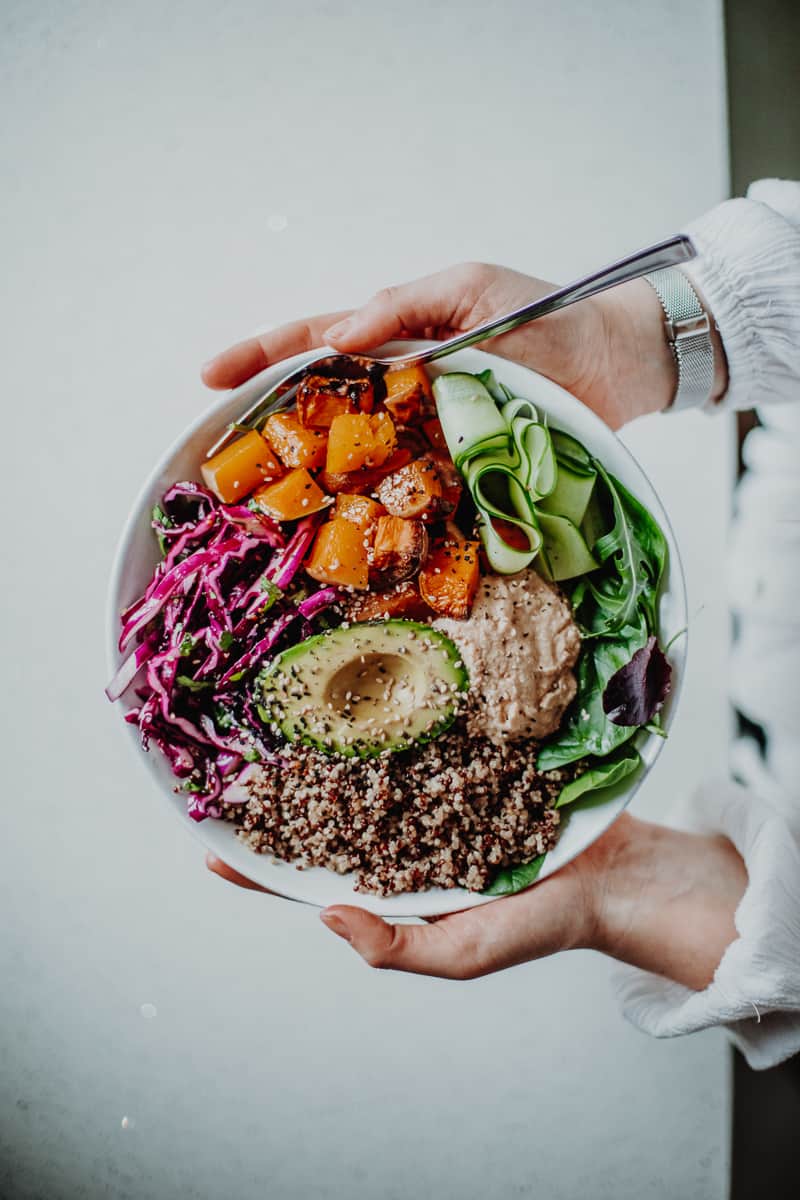 hands holding colorful nourish bowl