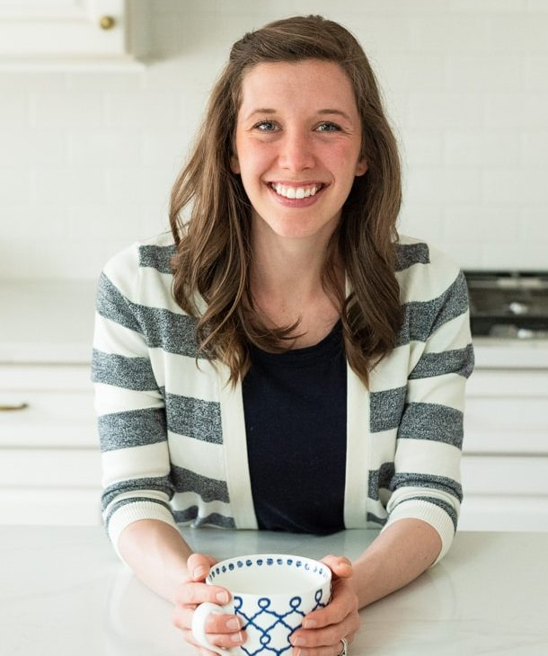 Libby Bloom, Durango, CO based registered dietitian and intuitive eating counselor smiling with her hands wrapped around a blue and white mug