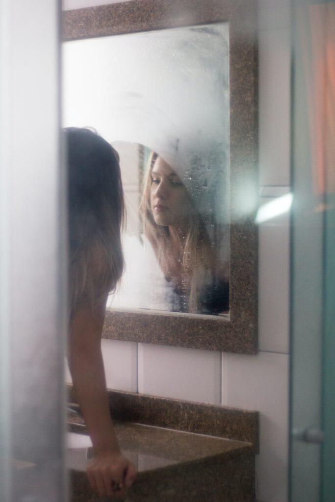 woman looking at herself in a steamy mirror