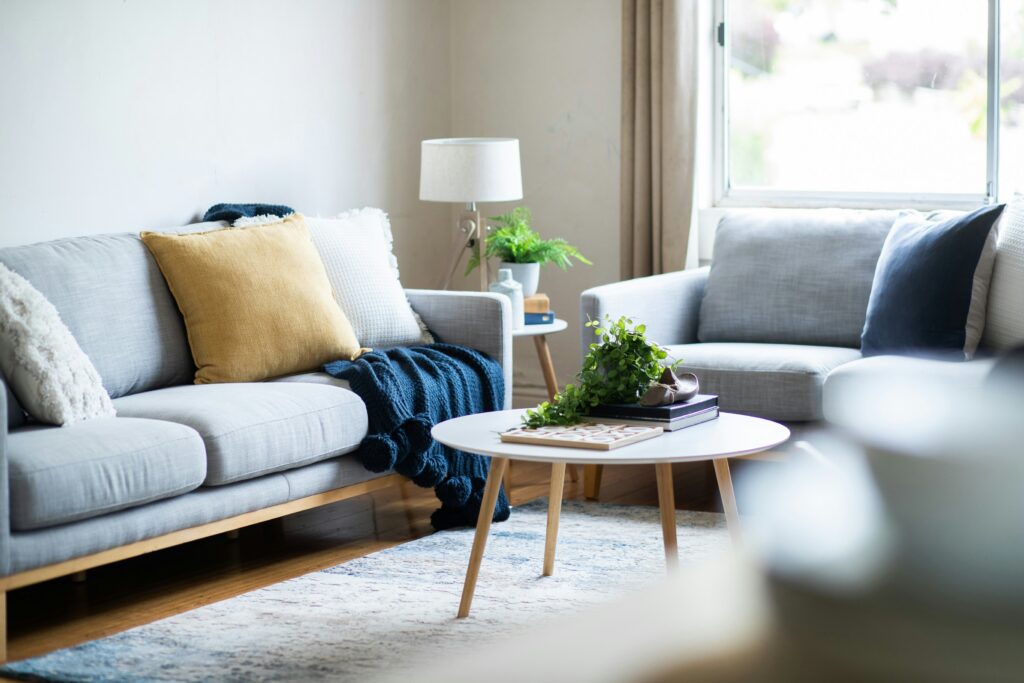 Living room image with a gray couch and round coffee table